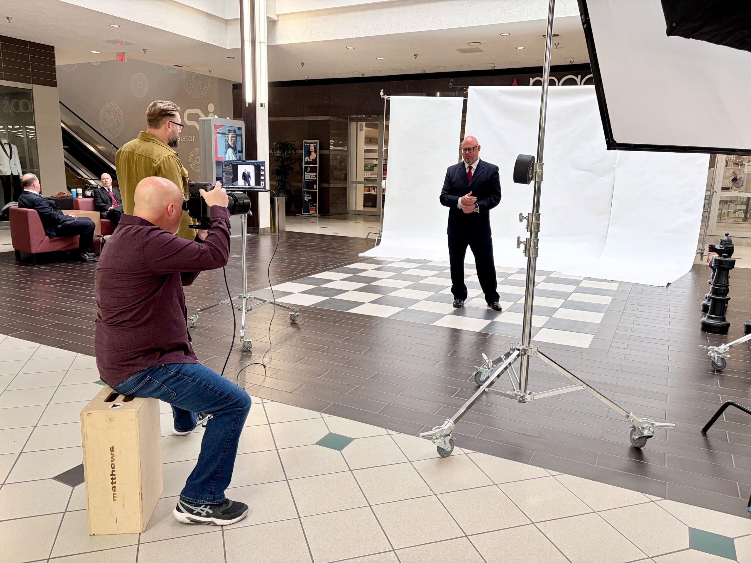 Steven Paul Photographer capturing an executive portrait of a businessman in a suit against a white backdrop inside Vancouver Mall.