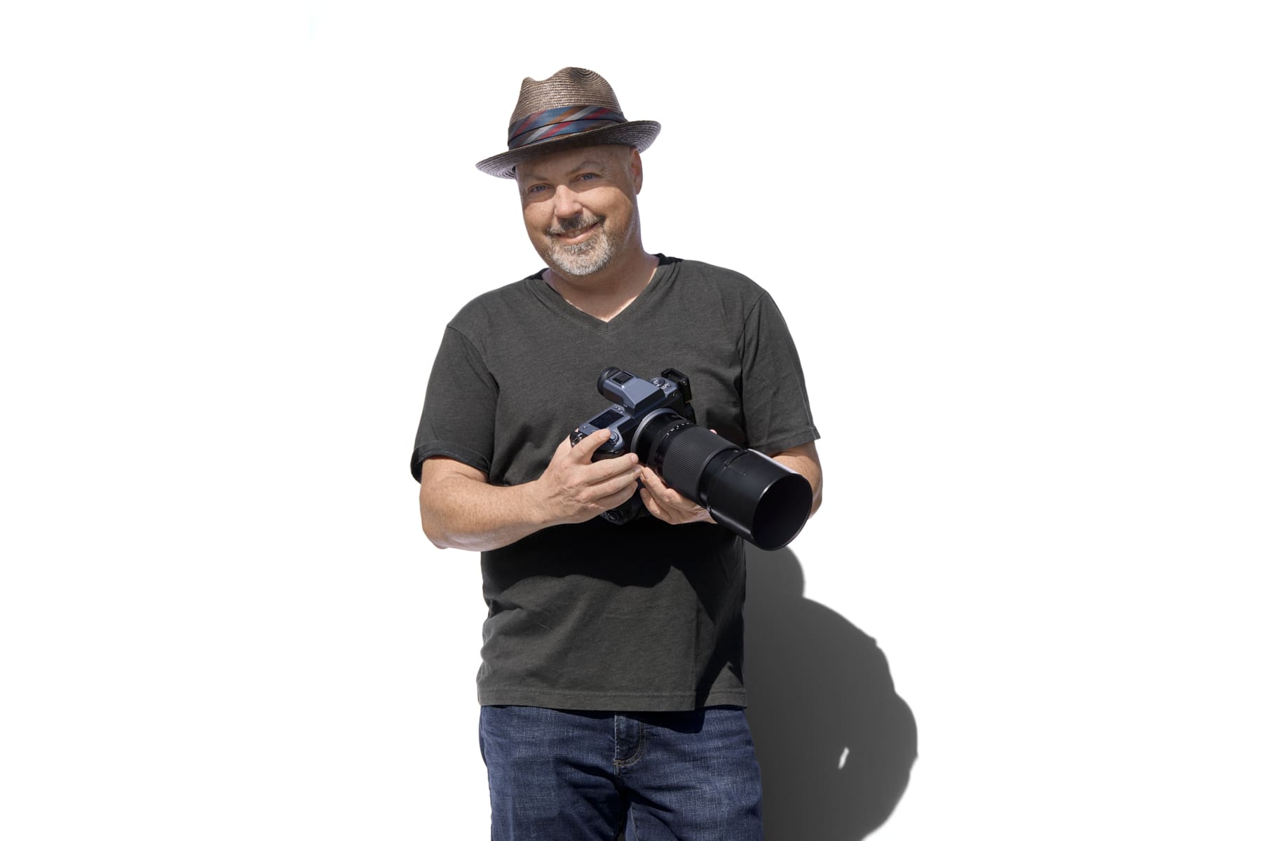 Steven Paul, Vancouver WA headshot and branding photographer, smiling while holding a camera against a white background
